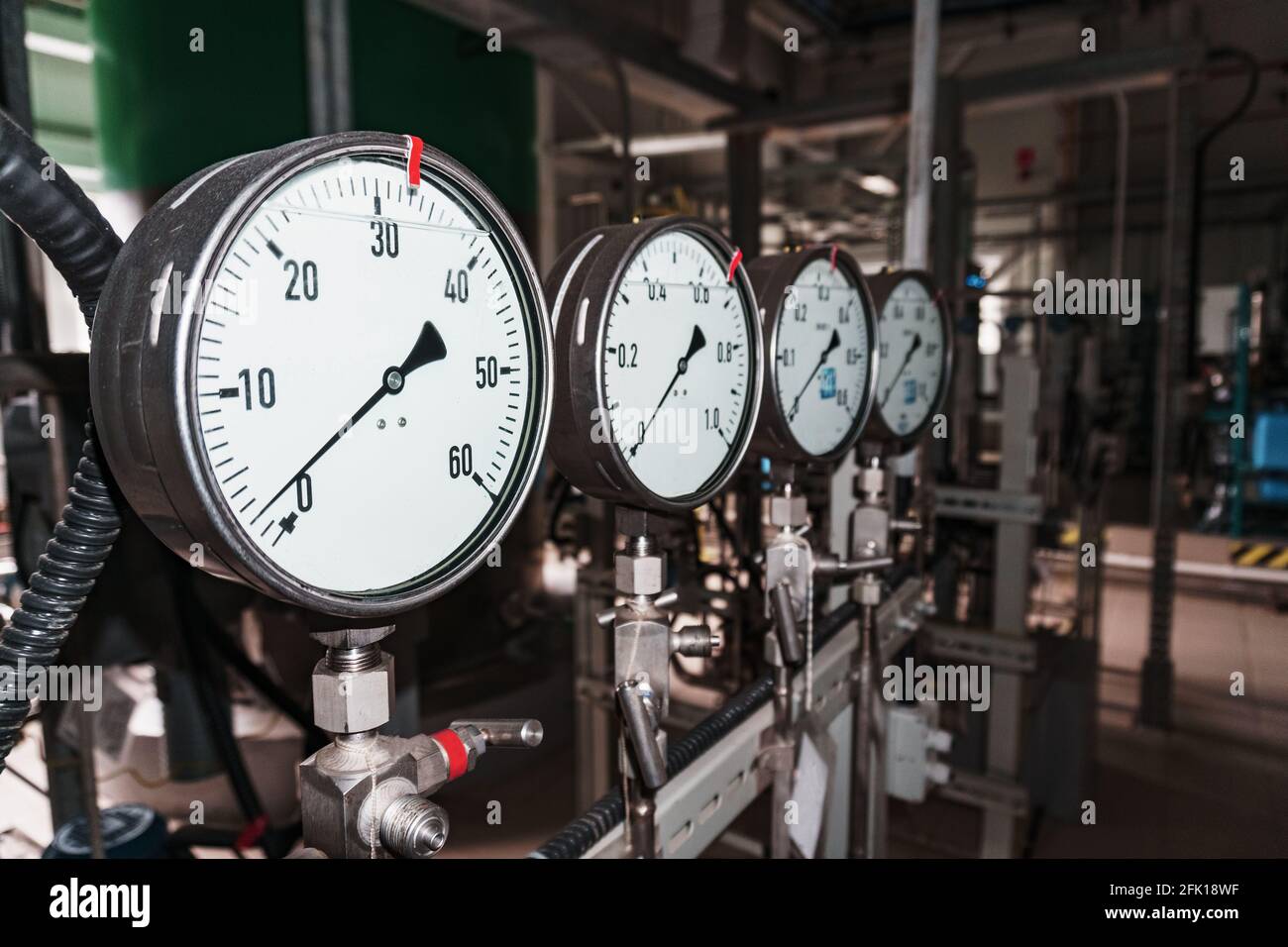 Das Manometer ist ein Nahaufdruck-Messgerät in einer Reihe. Messung des Flüssigkeits- und Gasdrucks in Industrieanlagen Stockfoto