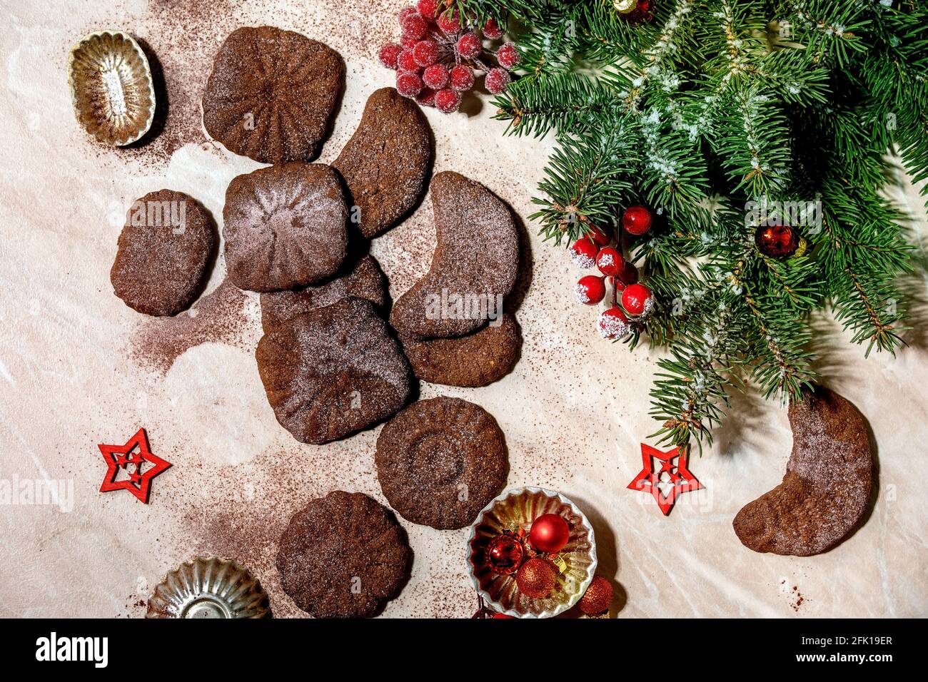 Hausgemachte traditionelle Weihnachten Mürbeteig Cookies Schokolade Crescents mit Kakao Puderzucker mit Plätzchen Formen, Tanne, rote Weihnachtssterne Dekorationen. Stockfoto