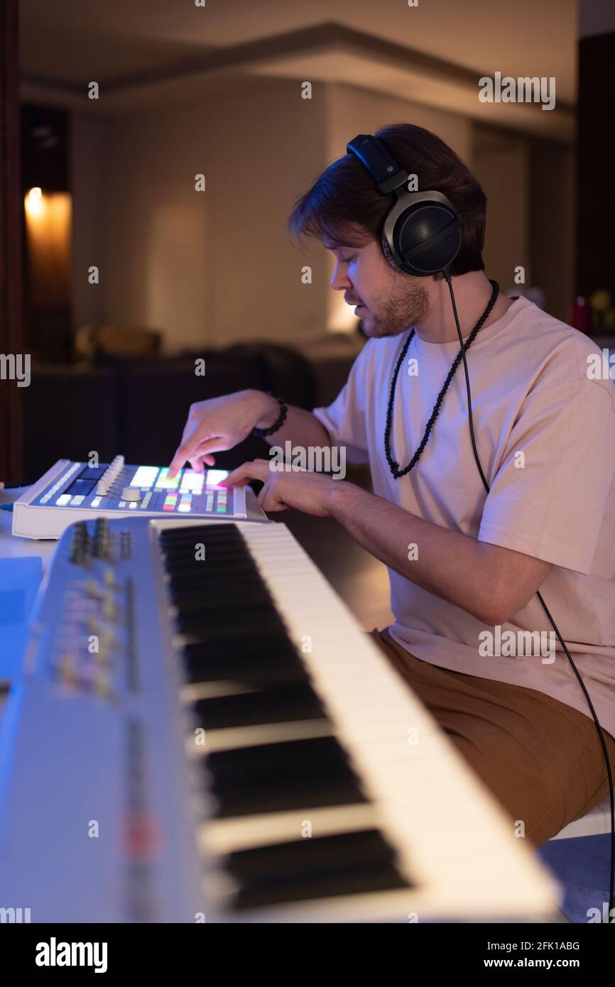 Männlicher Musiker mit Soundboard zu Hause Stockfoto