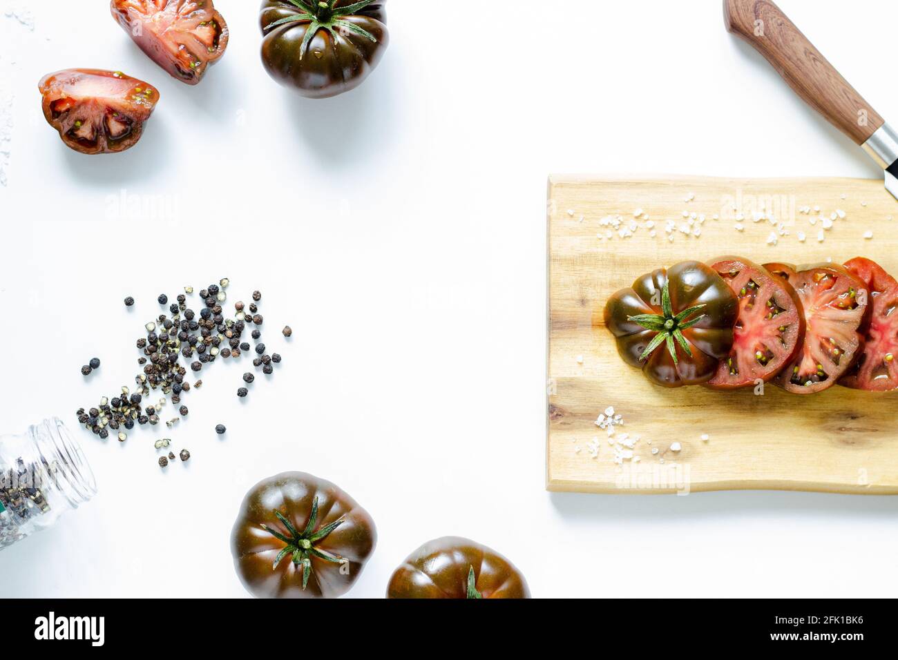 Schneiden und ganze rote Tomaten auf Holz Schneidebrett und Weißer Hintergrund Stockfoto