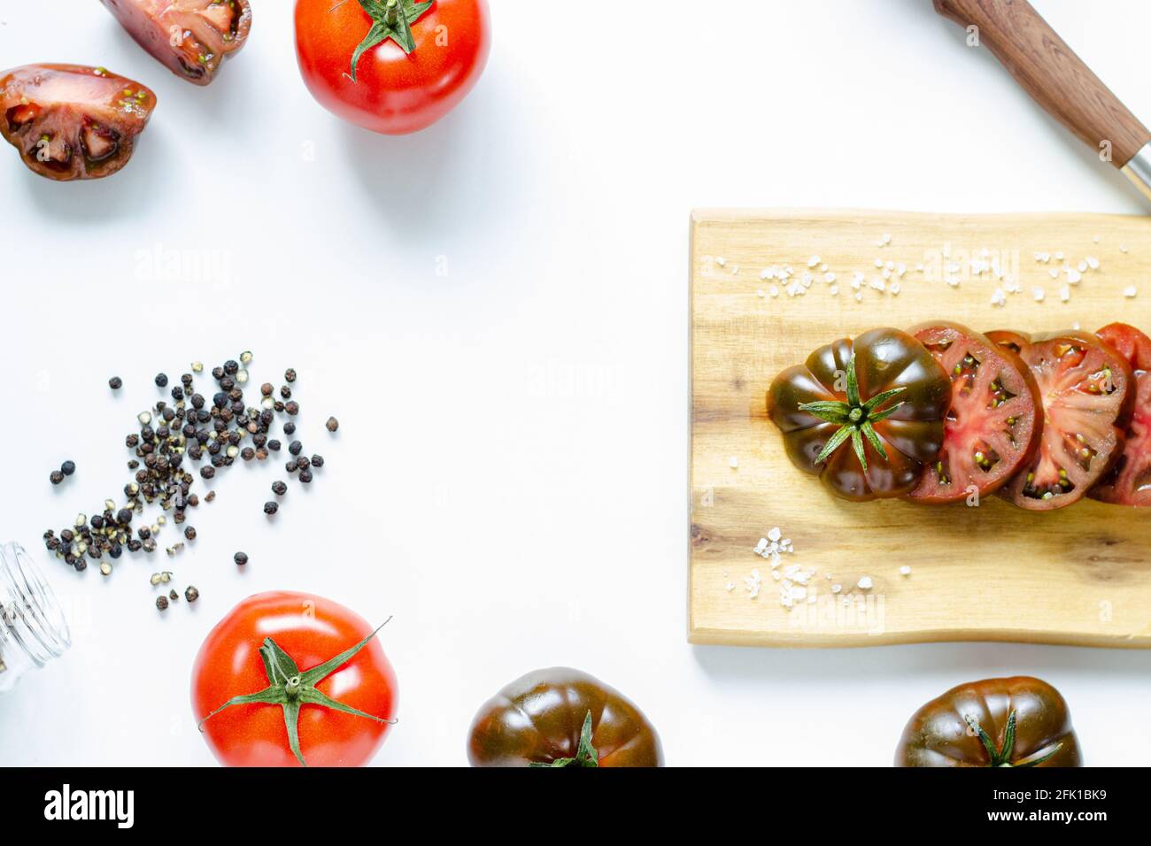 Schneiden und ganze rote Tomaten auf Holz Schneidebrett und Weißer Hintergrund Stockfoto