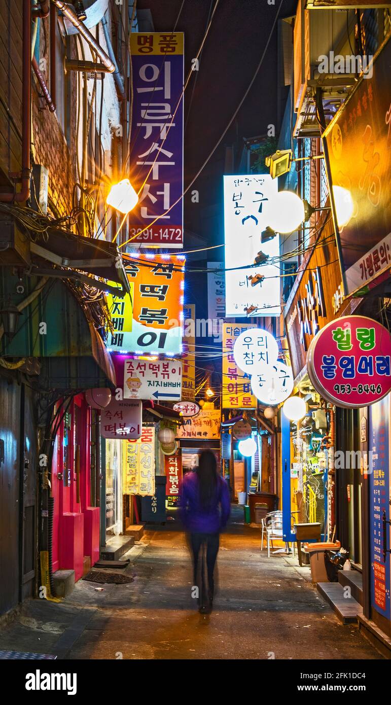 Frau, die durch die Hintergasse in Seoul läuft Stockfoto