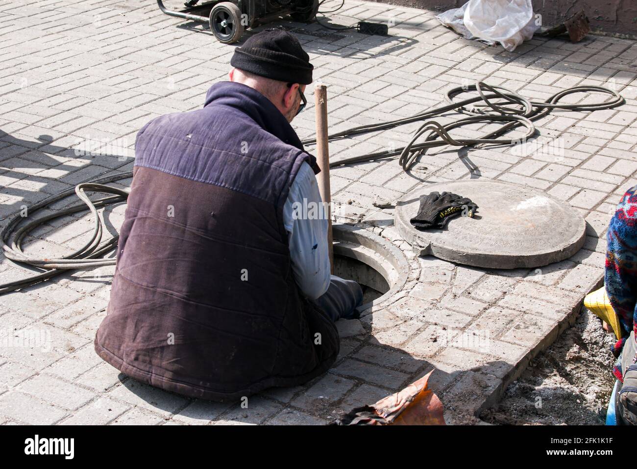 Dnepropetrovsk, Ukraine - 03.26.2021: Wasserversorger öffnen ein altes Kanalloch und ersetzen alte rostige Rohre durch neue. Stockfoto