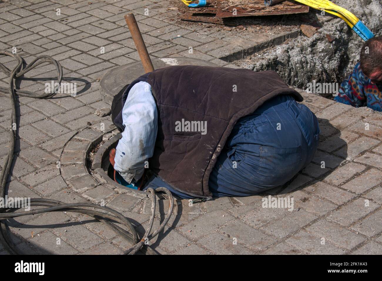 Dnepropetrovsk, Ukraine - 03.26.2021: Wasserversorger öffnen ein altes Kanalloch und ersetzen alte rostige Rohre durch neue. Stockfoto