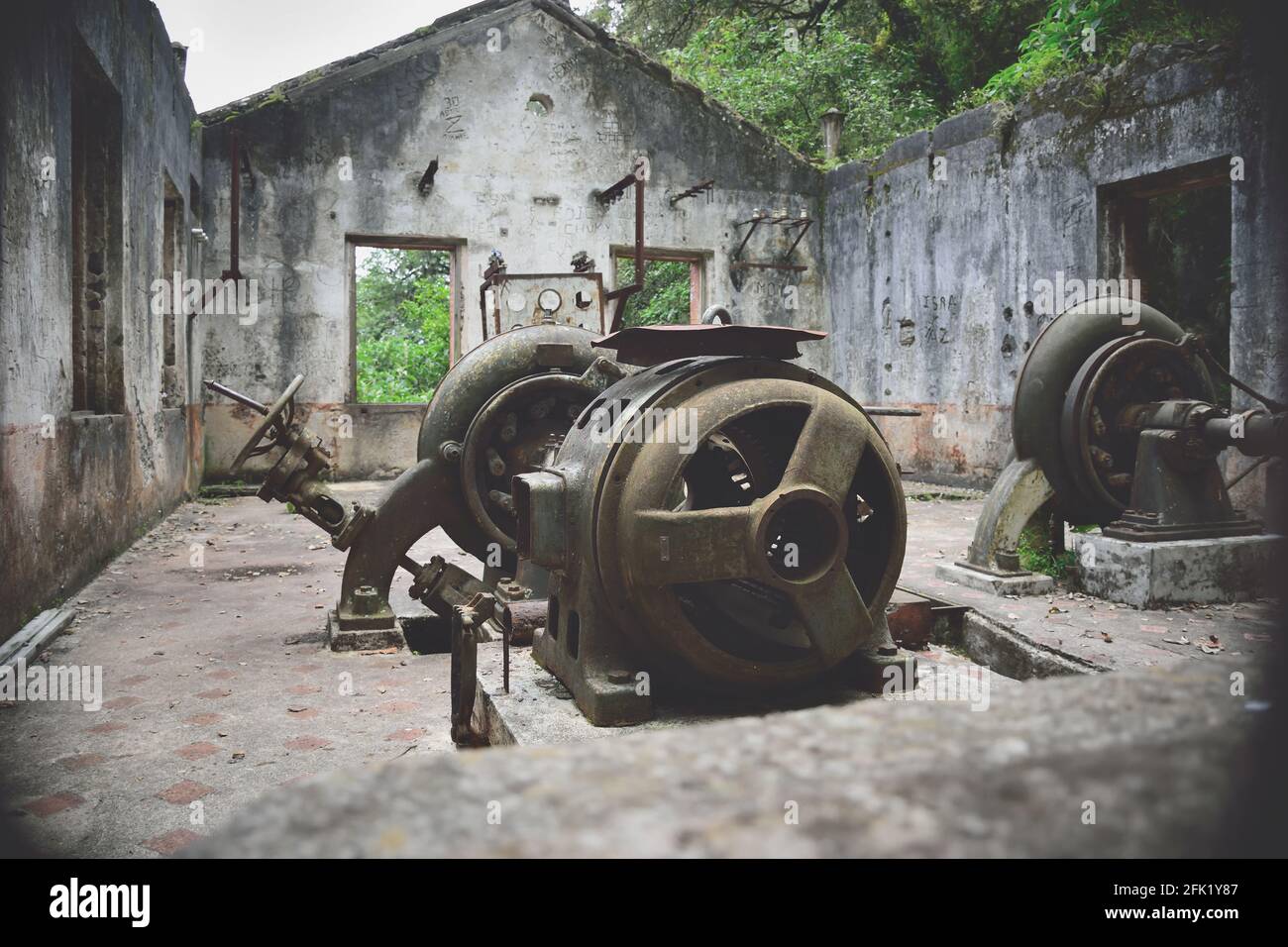 Alte und verlassene Fabrik, die noch sehr alte Maschinen hat, alte Strukturen, die mitten im Wald sind Stockfoto