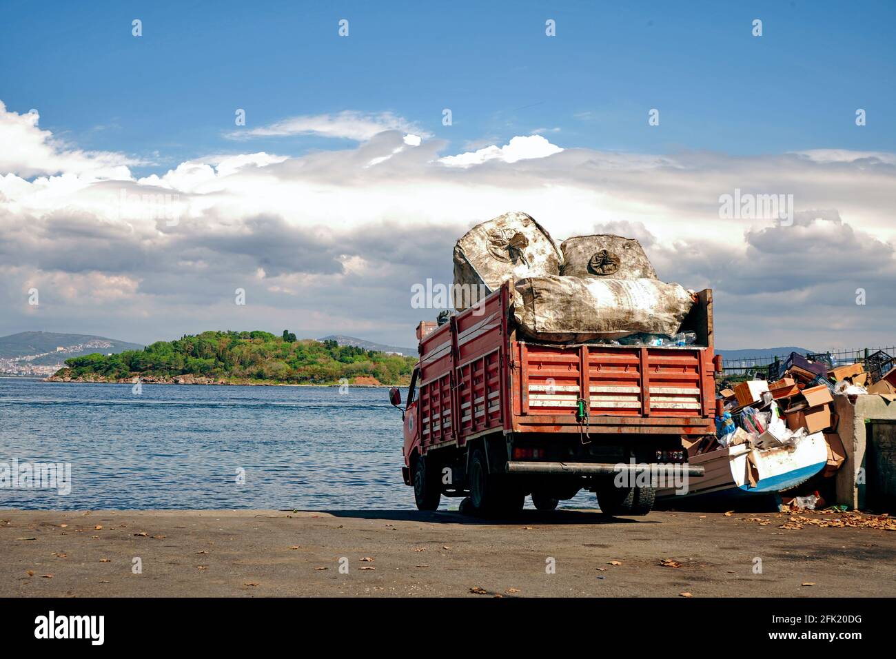 Ein Recycling-LKW in der Nähe des Meeres. Eine erstaunliche Meereslandschaft mit Verschmutzung der Umwelt Stockfoto