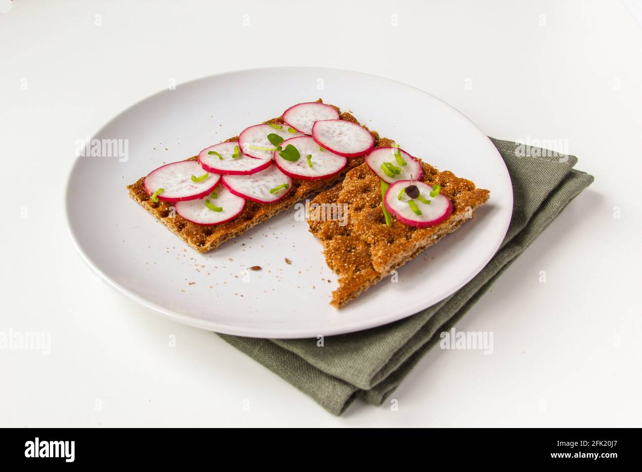 Brötchen mit gehackten Radieschen und Kräutern. Sandwich mit Gemüse und Basilikum. Stockfoto