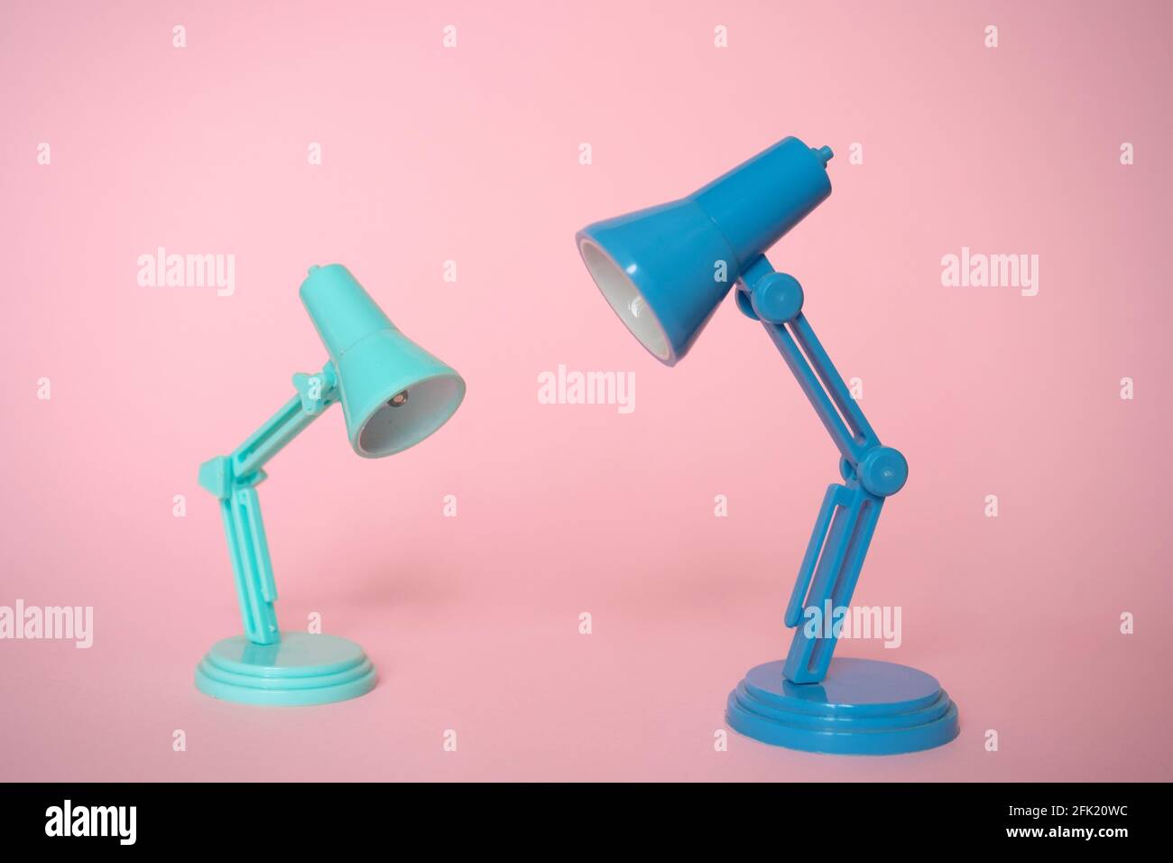Nahaufnahme der modernen Minze- und blauen Schreibtischlampen Rosa Hintergrund Stockfoto