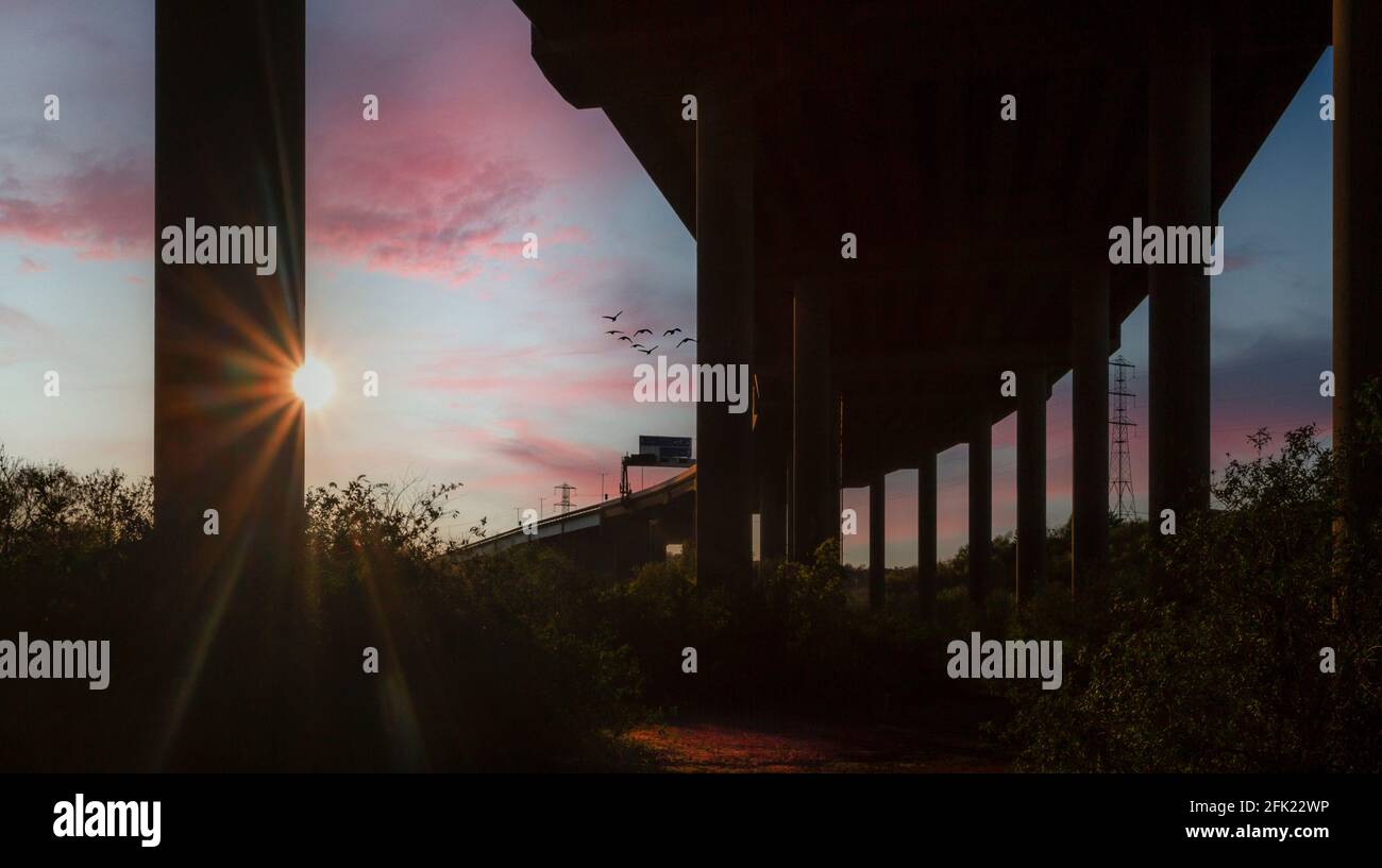 Sonnenuntergang hinter den Säulen, die die Autobahn M4 in Port Talbot, Südwales, Großbritannien, unterstützen Stockfoto