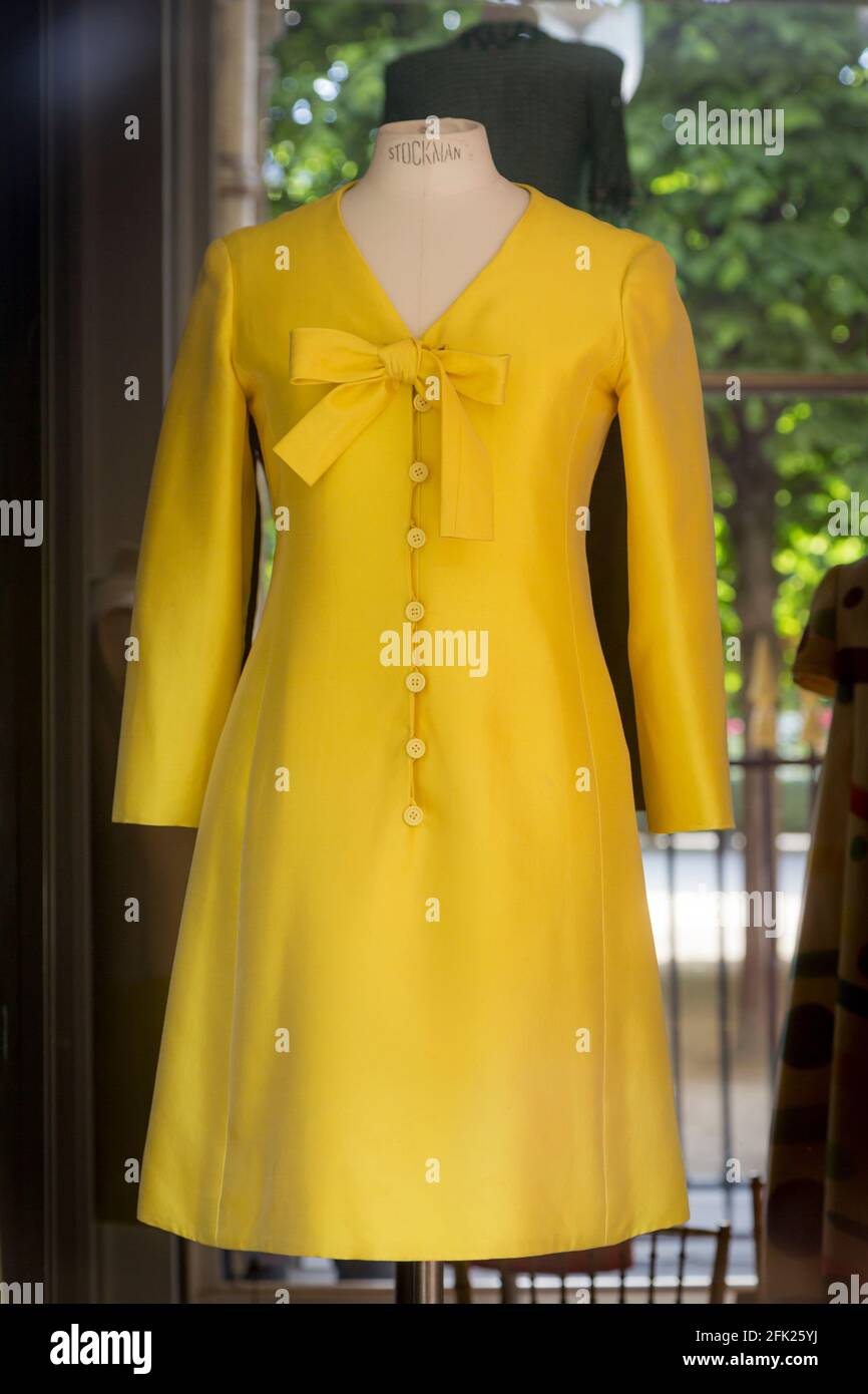 Klassisches gelbes Kleid in einer Schaufensterauslage in der Boutique des weltberühmten Designers Didier Ludot im Palais Royal, Paris, Frankreich Stockfoto