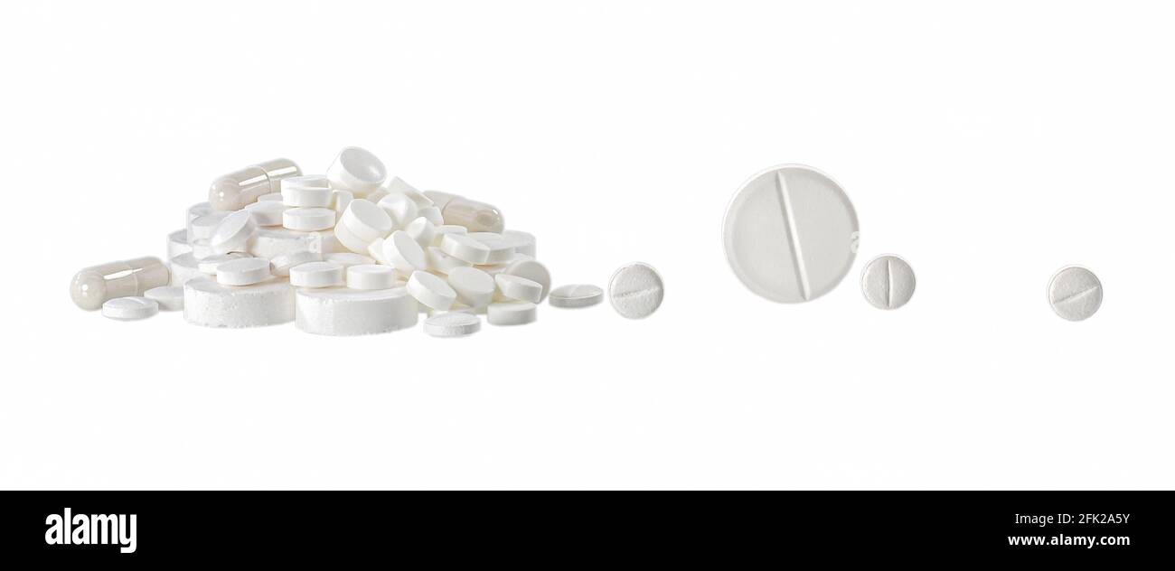Ein Dia von verschiedenen weißen Pillen und einzeln Rollen große und kleine Tabletten. Isoliertes Objekt auf weißem Hintergrund. Stockfoto