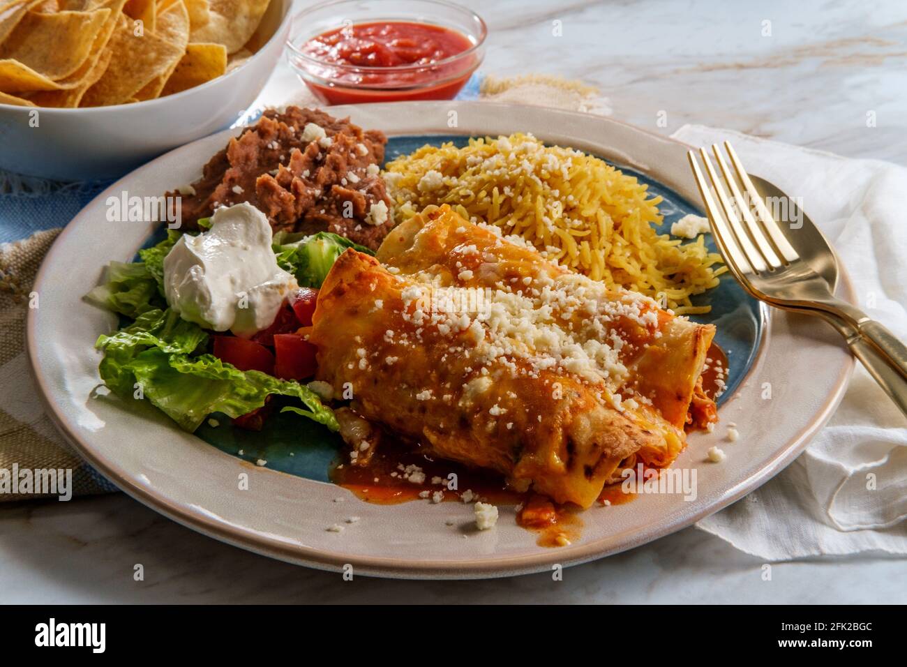 Traditionelles mexikanisches Enchiladas-Abendessen mit Reis und gebratenem Pinto Bohnen Stockfoto