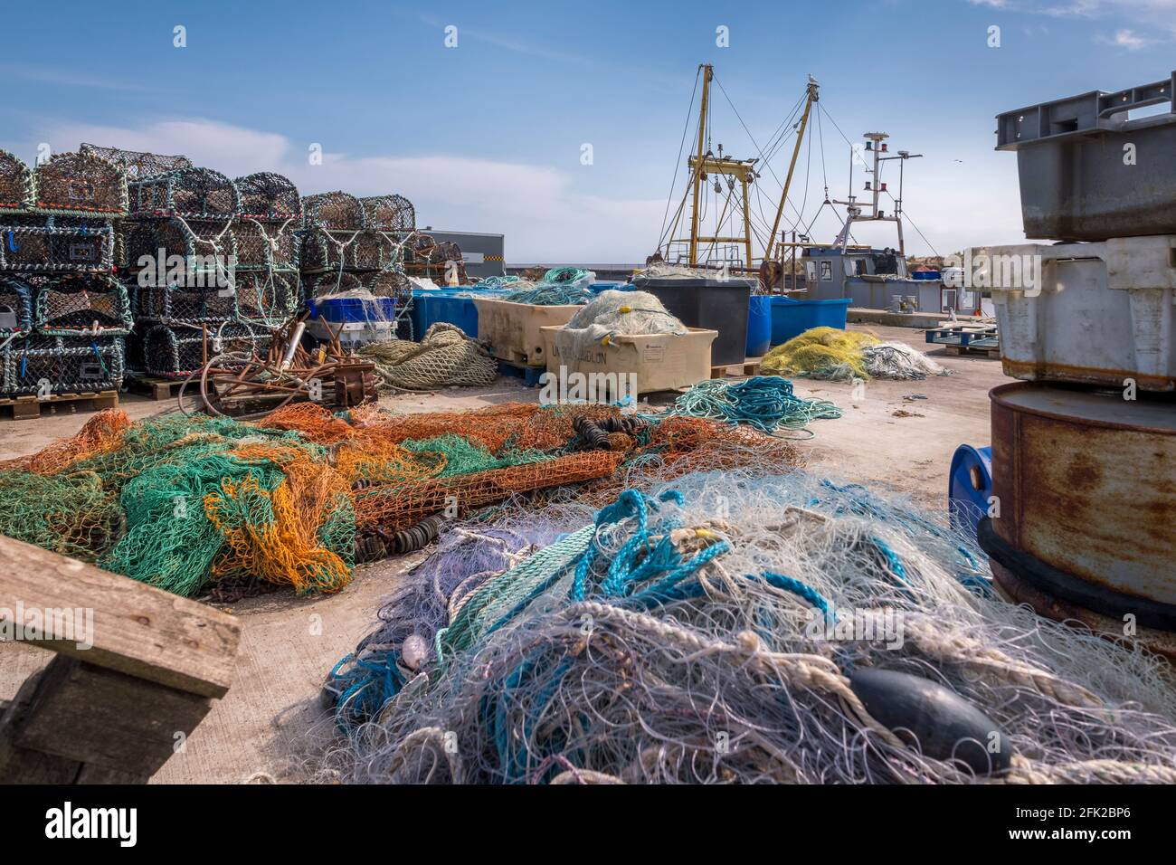 Fischernetze, Töpfe und Fischerboot im Hafen von Southwold, Suffolk, Großbritannien. Stockfoto