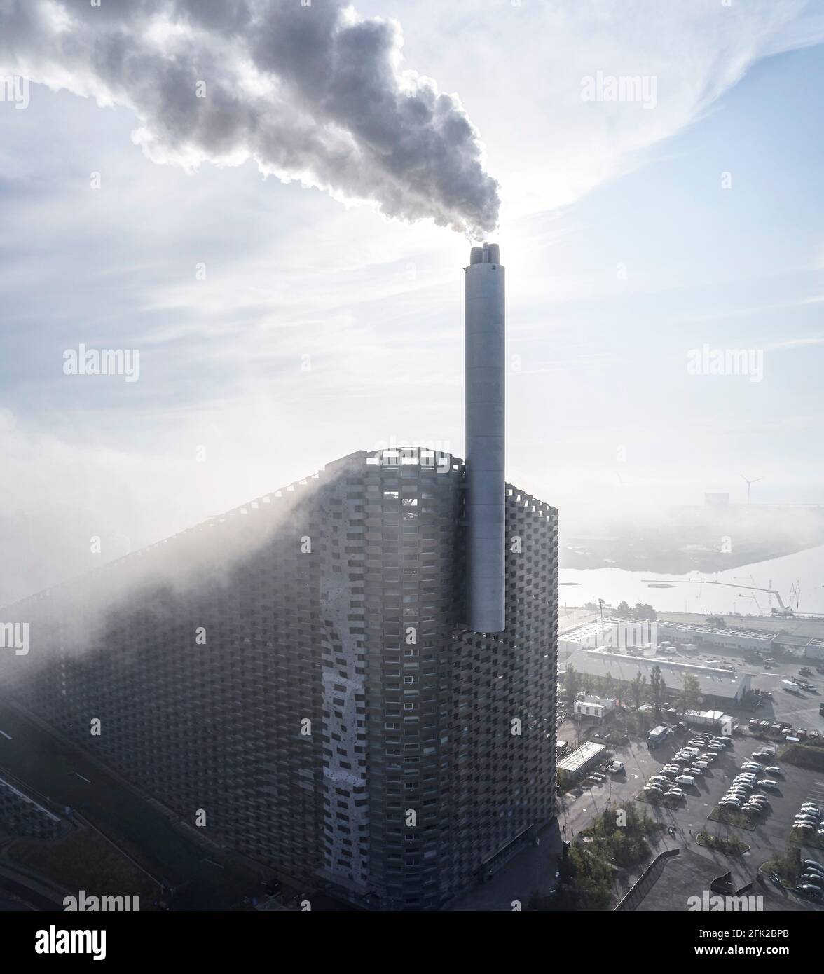 Blick mit Wolken, Fassade und Kontext. Kraftwerk CoppenHill, Kopenhagen, Dänemark. Architekt: BIG Bjarke Ingels Group, 2019. Stockfoto