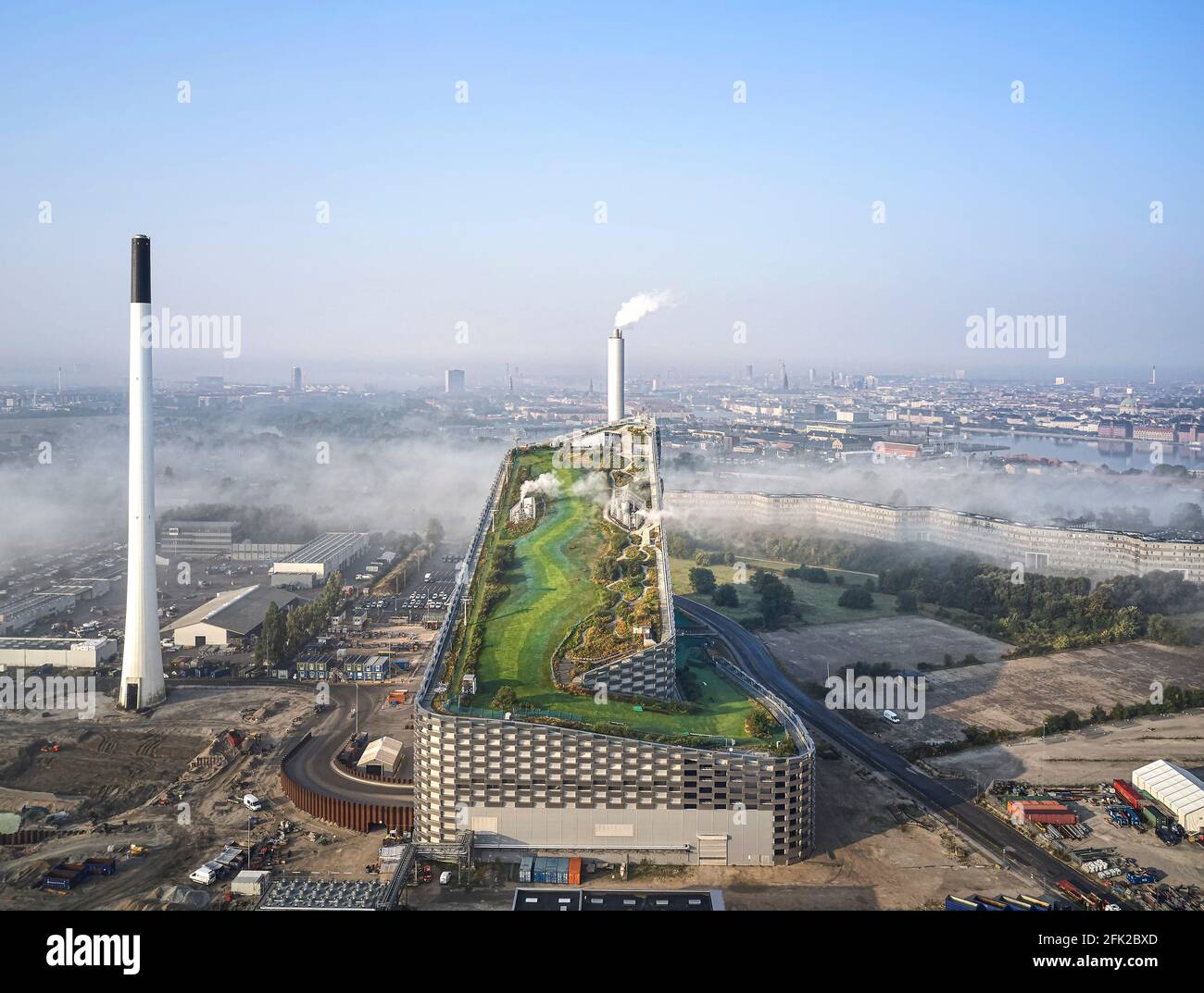 Fernsicht mit Wolken und Kontext. Kraftwerk CoppenHill, Kopenhagen, Dänemark. Architekt: BIG Bjarke Ingels Group, 2019. Stockfoto