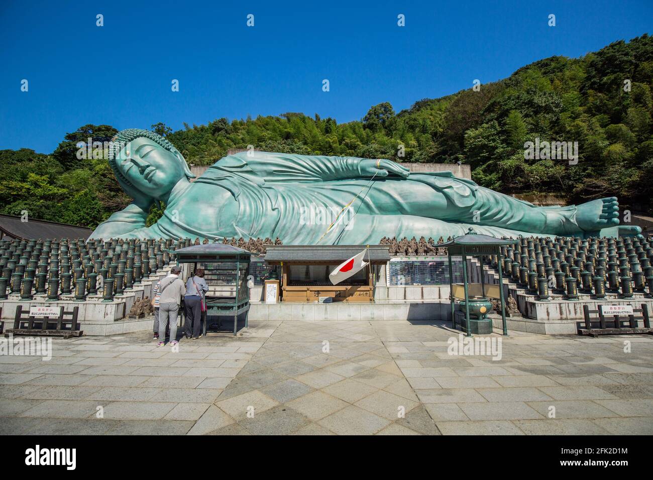 Buddhistischer Tempel von Nazoin mit dem sich rückenderen Buddha. Blauer Himmel und türkisfarbene Statue liegen auf der Seite. Längster Buddha der Welt. Fukuoka, Japan Stockfoto