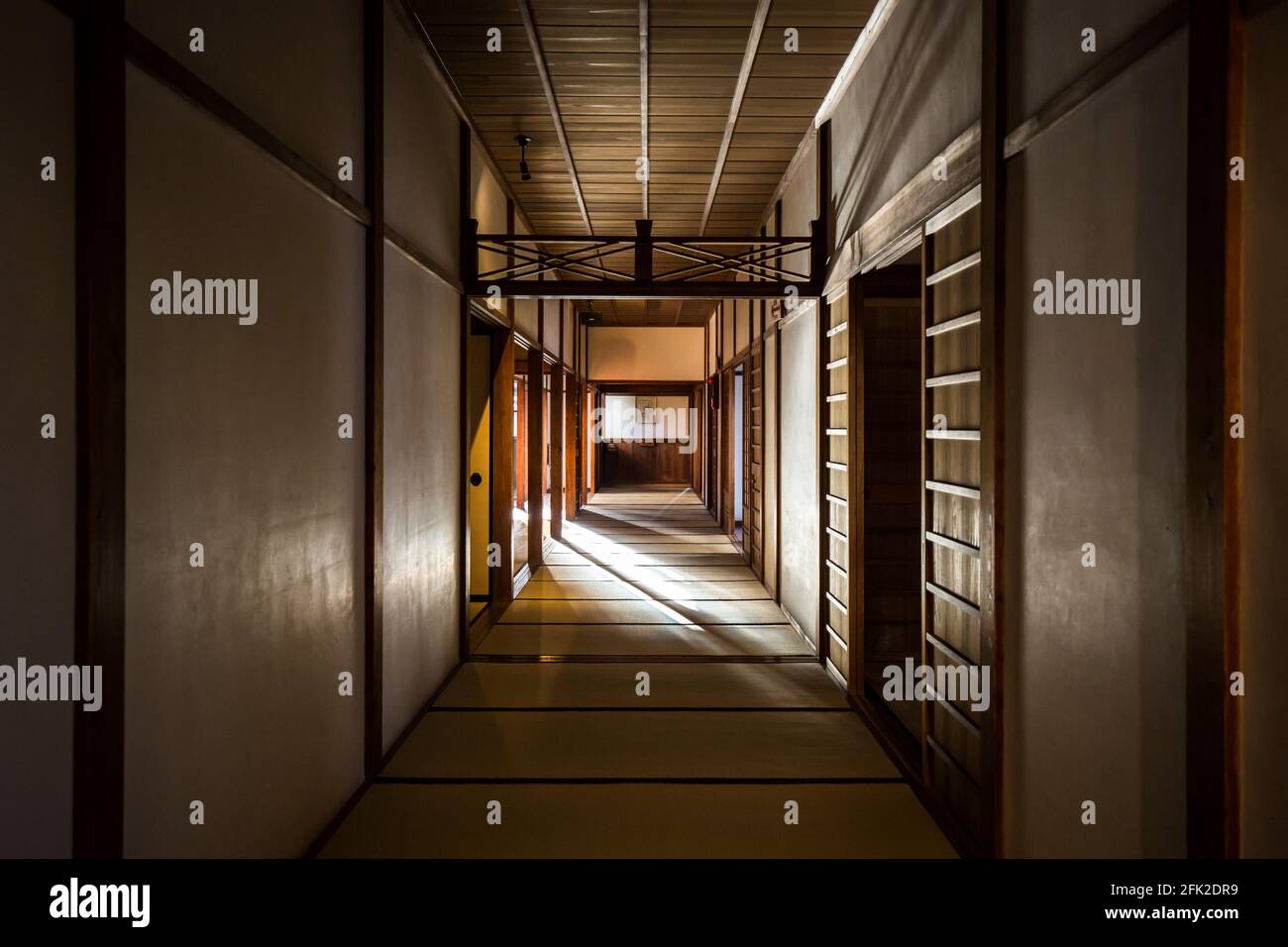 Lichtwelle über schwach beleuchteten, schattigen Korridor mit Tatami-Mattenboden im alten japanischen Samurai-Gebäude. Stockfoto