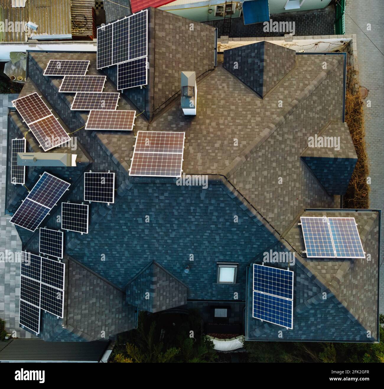 Luftaufnahme von Photovoltaik-Solarzellen auf einem eigenen Hausdach in einer kleinen europäischen Stadt. Konzept für erneuerbare grüne Energie Stockfoto