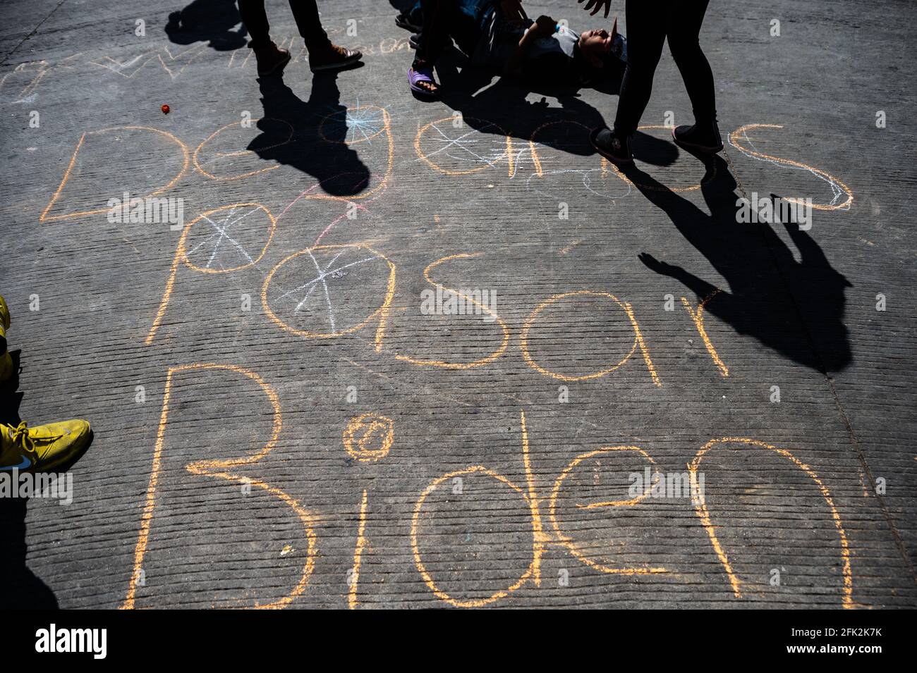 Tijuana, Mexiko. April 2021. Kinder schreiben auf Kreide 'Dejenos Pasar Biden' (Lasst uns in Biden) auf der Straße, wo das Chaparral Camp in Tijuana weiter wächst. Quelle: Raquel Natalicchio/ZUMA Wire/Alamy Live News Stockfoto