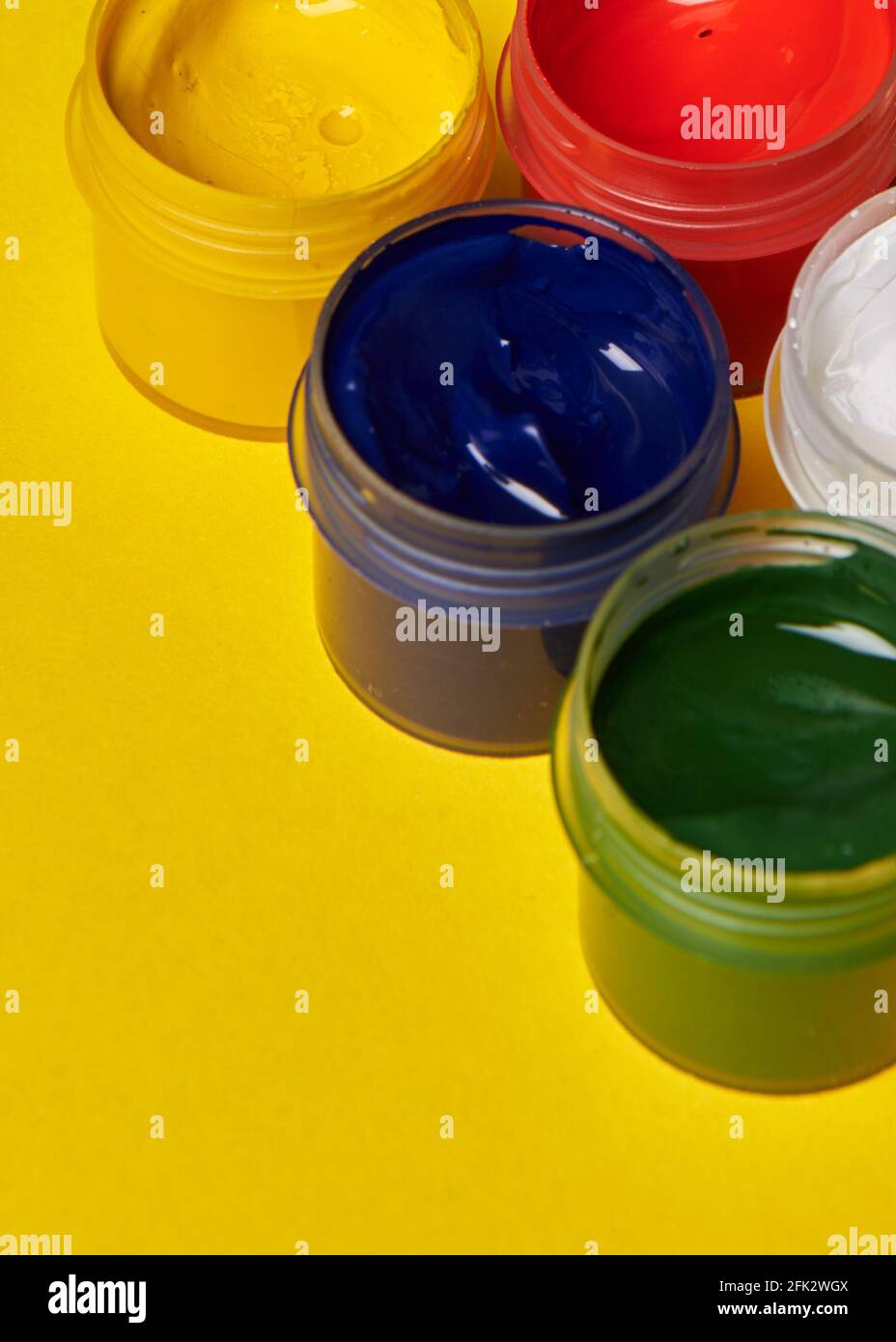 Bunte Farbdosen auf gelbem Hintergrund Stockfoto