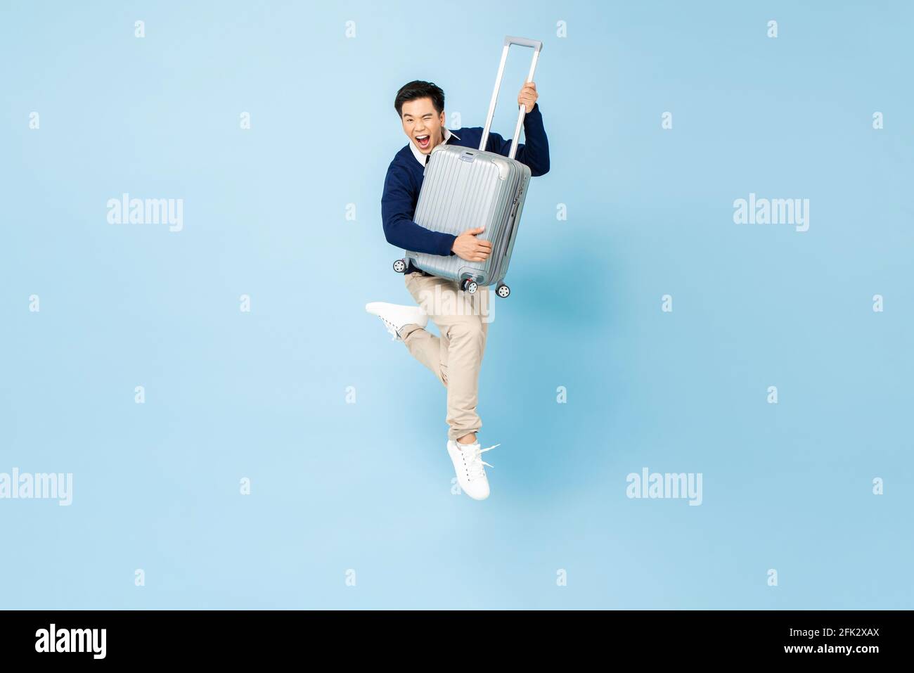 Porträt eines jungen aufgeregten, gutaussehenden asiatischen Touristen mit Gepäck Springen in der Luft bereit, um isoliert auf hellblau zu reisen studio-Hintergrund Stockfoto Porträt eines jungen aufgeregten, gutaussehenden asiatischen Touristen mit Gepäck Springen in der Luft bereit, um isoliert auf hellblau zu reisen studio-Hintergrund Stockfoto