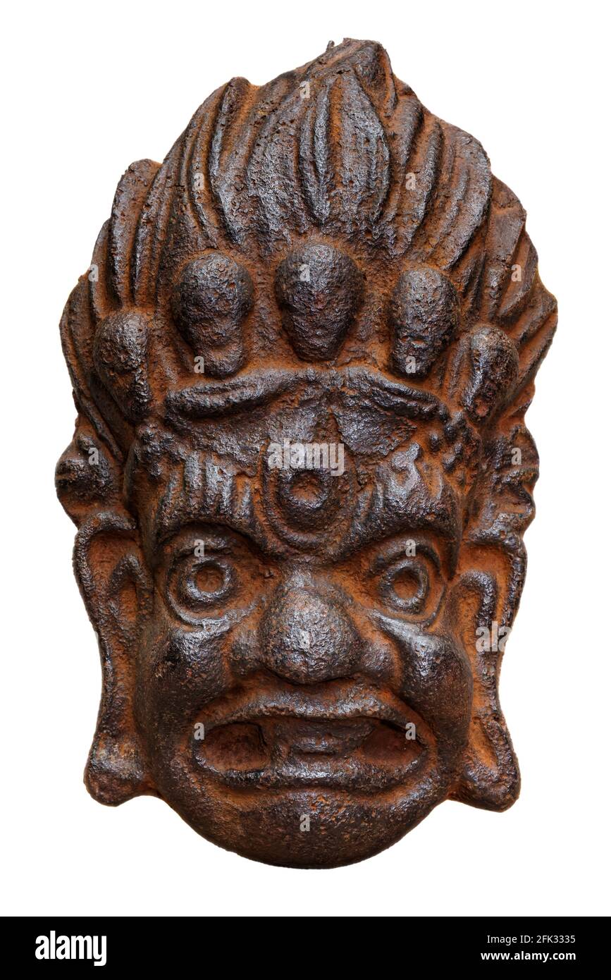 Traditionelle gusseiserne Maske von Mahakala, Great Time god, alt und rostig, isoliert auf weißem Hintergrund Stockfoto