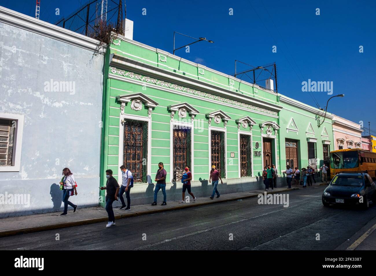Fußgänger gehen vor einem prunkvollen Haus, Mérida, Yucatán, Mexiko Stockfoto