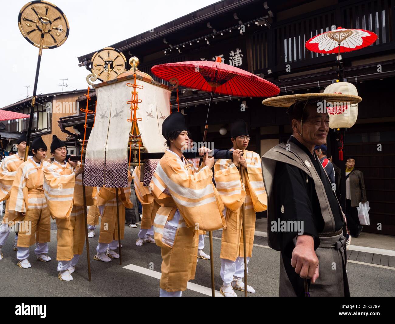 Takayama, Japan - 10. Oktober 2015: Einheimische Männer tragen in traditionellen Kostümen einen tragbaren Schrein entlang der engen Straßen der Altstadt von Takayama Stockfoto