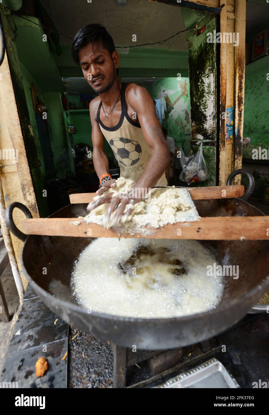 Ein Inder, der in einem kleinen Laden in der Altstadt von Varanasi, Indien, frittierte Snacks zubereitete. Stockfoto