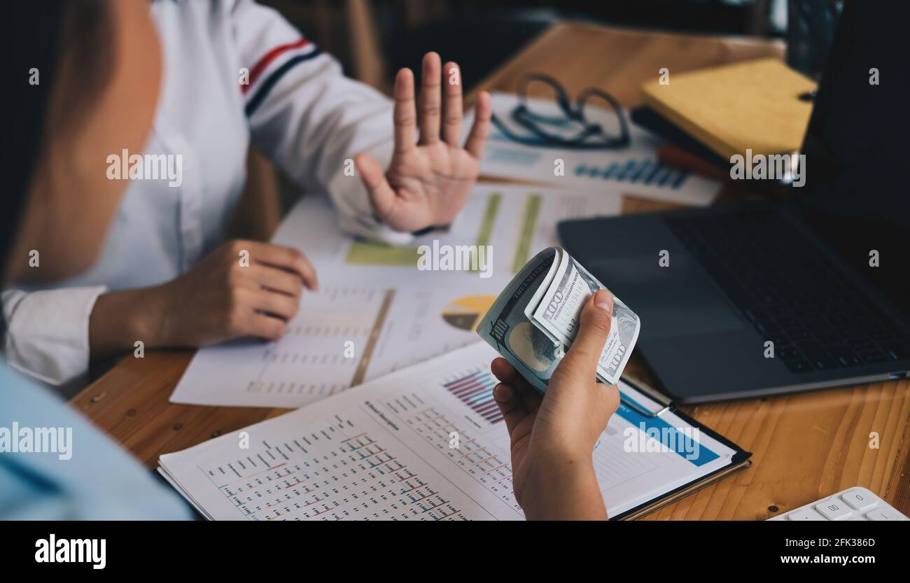 Geschäftsfrau Ablehnung Geld in weißem Umschlag von seinem Partner im Dunkeln angeboten - Anti-Bestechung-Konzept. Stockfoto