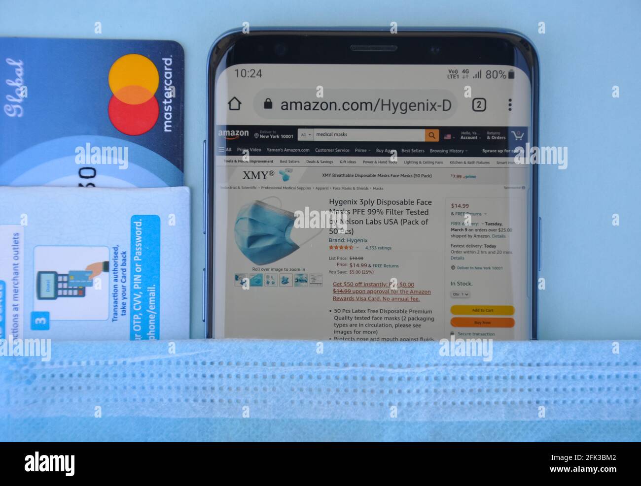 Mandi, Himachal Pradesh, Indien - 03 04 2021: Hoher Winkel des Kaufens der medizinischen Maske online mit Mastercard, Amazon-Website auf Smartphone, das ein weltweit Top-internationales elektronisches Handelsunternehmen ist Stockfoto