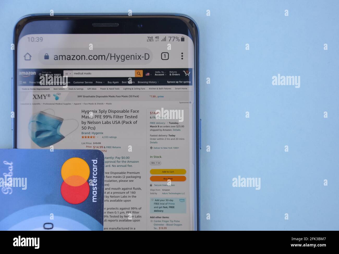 Mandi, Himachal Pradesh, Indien - 03 04 2021: Hoher Winkel des Kaufens der medizinischen Maske online mit Mastercard, Amazon-Website auf Smartphone, das ein weltweit Top-internationales elektronisches Handelsunternehmen ist Stockfoto