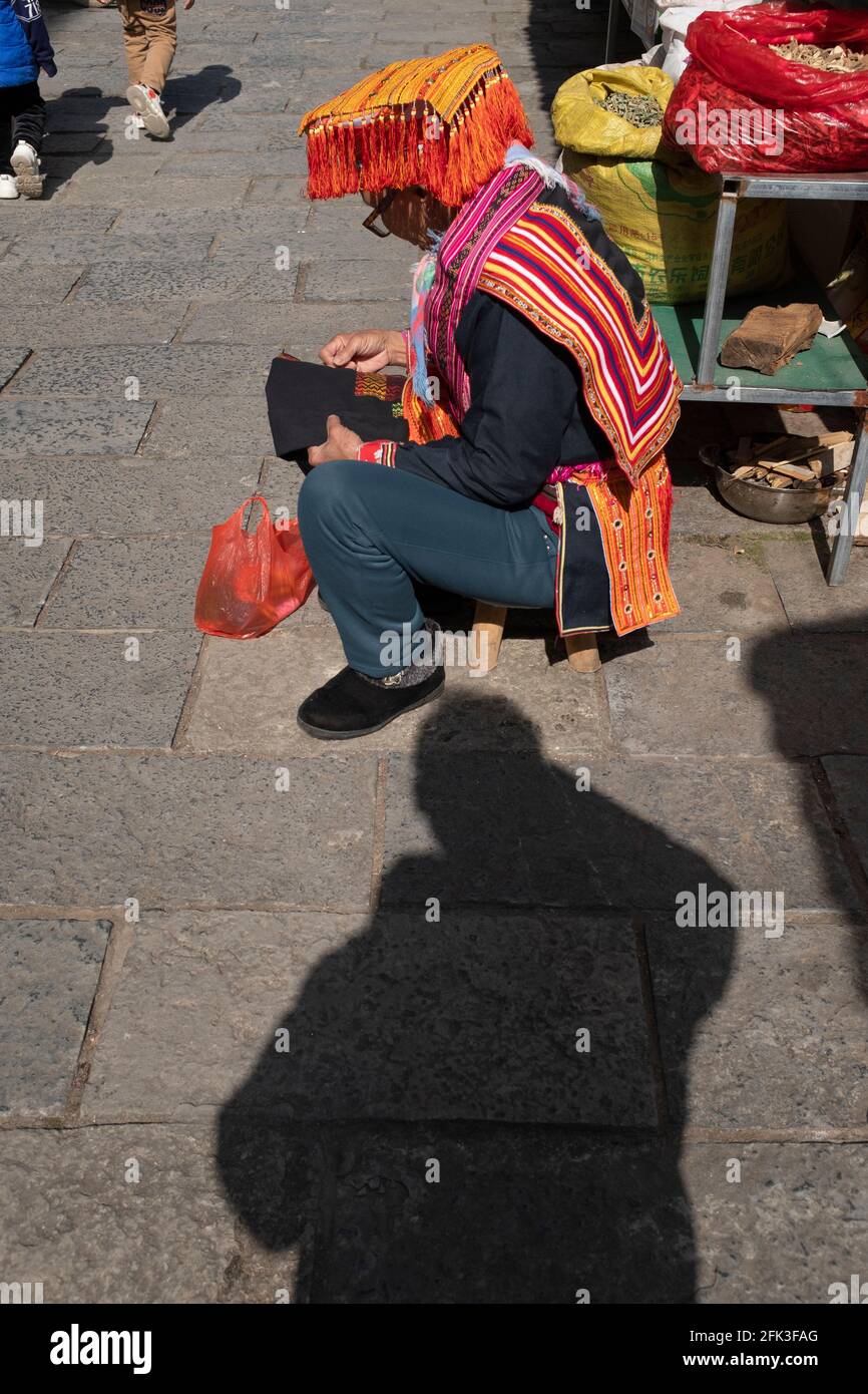 Eine alte Frau stickt unter der Sonne im Kostüm Der yao Nationalität China Stockfoto