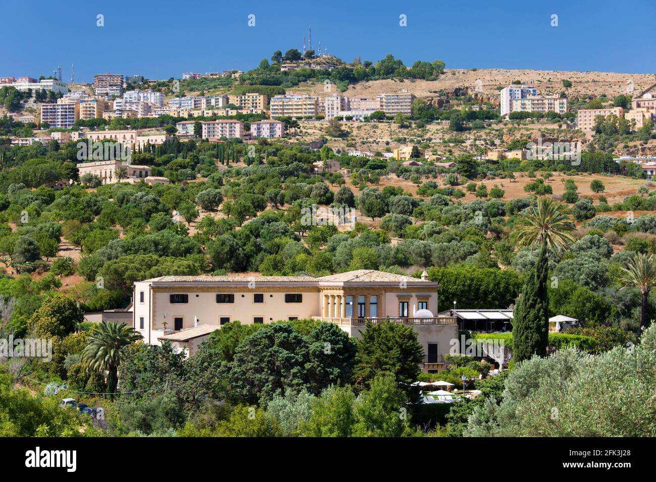 Agrigento, Sizilien, Italien. Blick auf die Stadt durch grüne Landschaft mit Oliven- und Mandelhainen, Tal der Tempel, Hotel Villa Athene prominent. Stockfoto