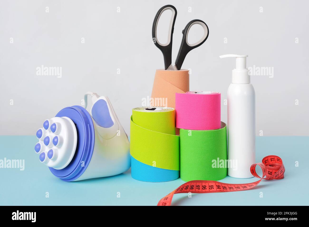 Tragbares Massagegerät, Rollen Kinesiologieband, Schere und antiseptische Flasche Stockfoto