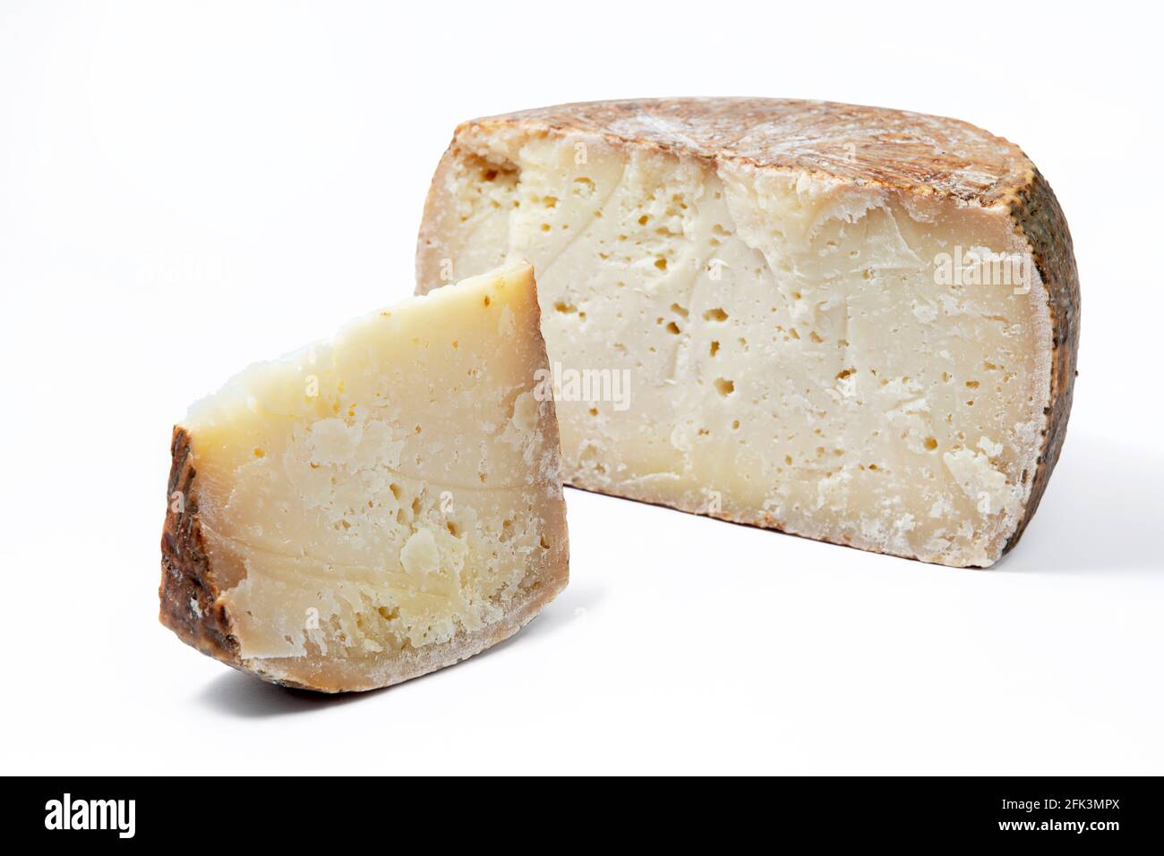 Ein Stück gereiftem Pecorino-Käse mit Käserad auf weißem Hintergrund Stockfoto