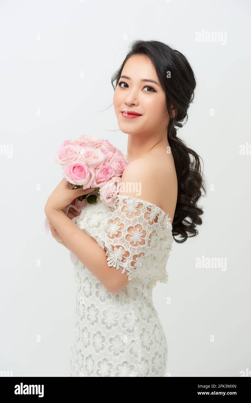 Frau im Hochzeitskleid mit Blumenstrauß. Stockfoto