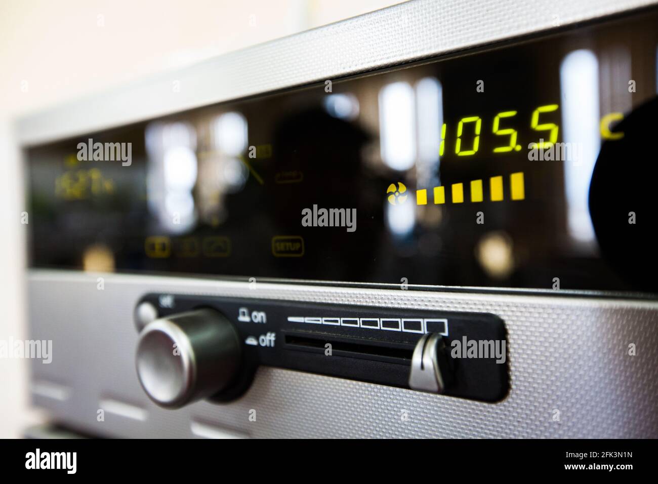 Nahaufnahme und perspektivische Ansicht auf UKW-Radio. Teilweise verschwommenes Foto. Graues Metallgehäuse, schwarzes Kunststoff-Displayglas. Abstrakter industrieller Hintergrund. Stockfoto