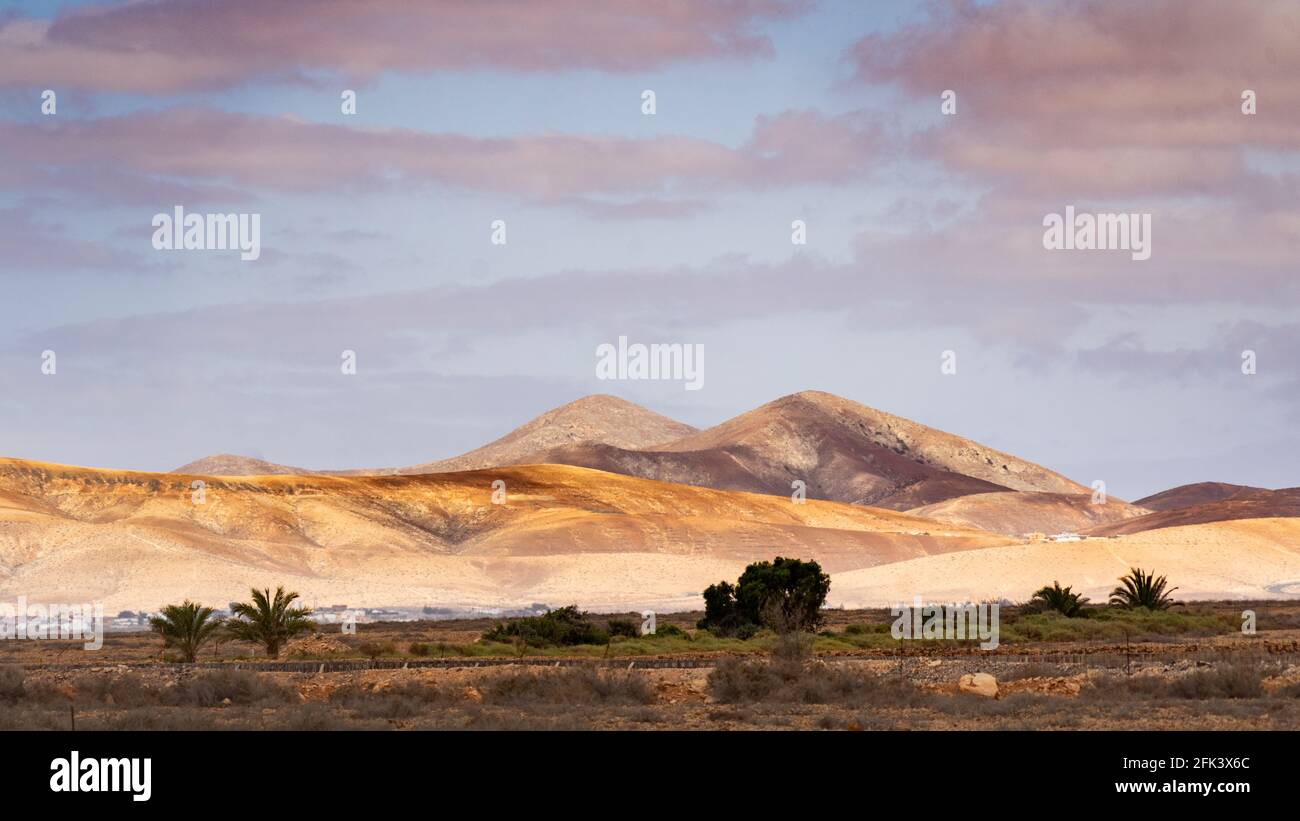 Sonnenlicht und Wolkenschatten auf einer Wüstenlandschaft mit Zwilling Berge am Horizont Stockfoto