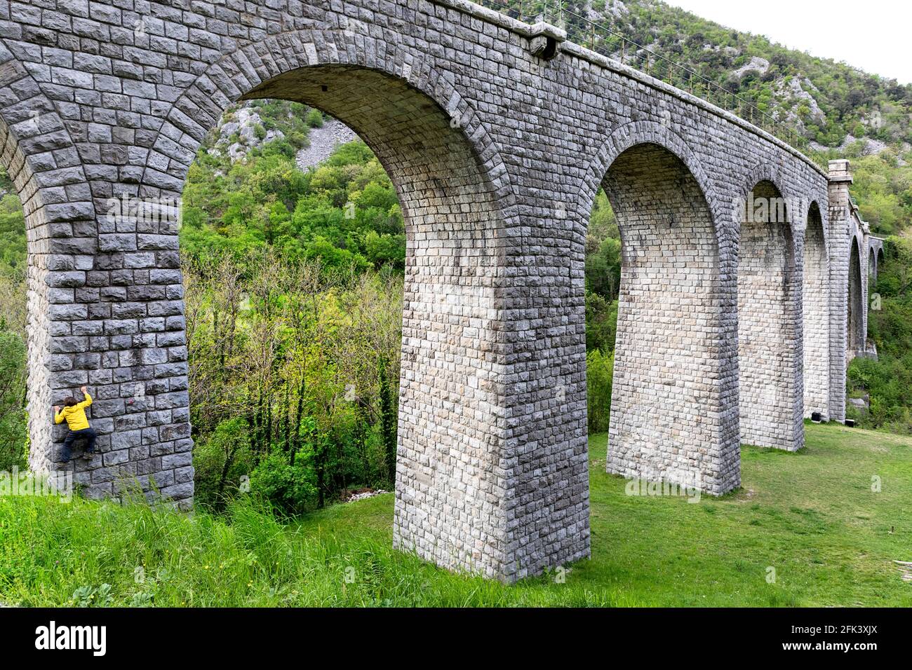 Junge klettert die Solkan-Brücke auf dem Fluss Soca (Isonzo), Slowenien Stockfoto