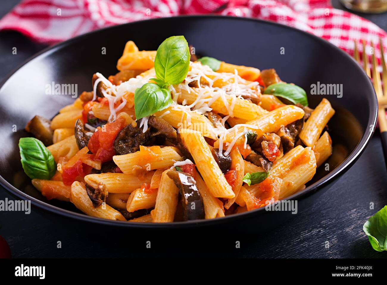 Pasta Penne mit Auberginen. Pasta alla norma – traditionelle italienische Küche mit Auberginen, Tomaten, Ricotta-Käse und Basilikum. Stockfoto