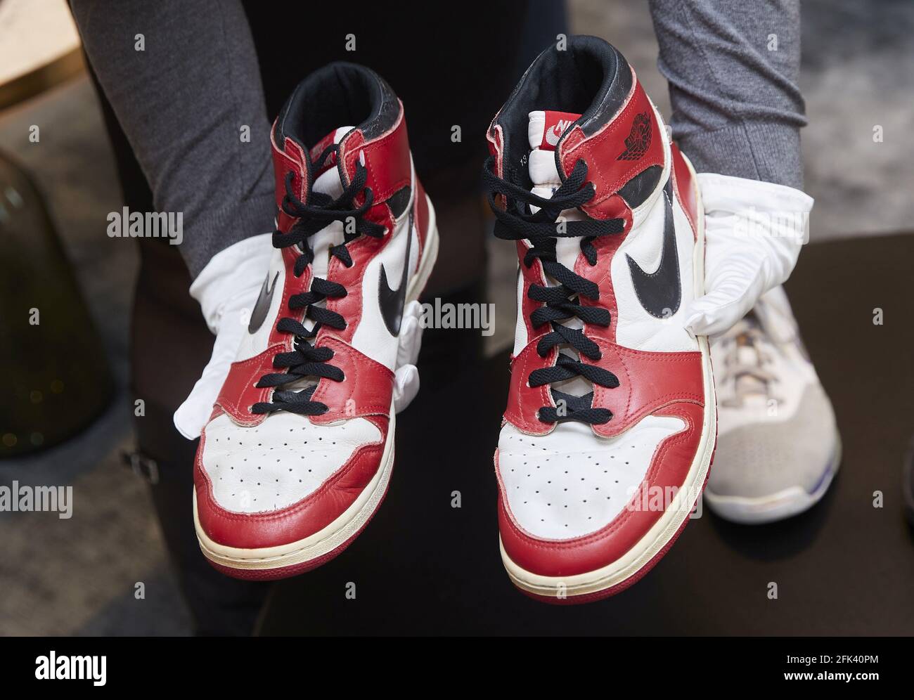 A Sotheby's Mitarbeiter halten ein Paar „Air Jordan 1“-Schuhe, die der  NBA-Champion Michael Jordan während seiner Rookie-Saison 1984-85 bei den  Chicago Bulls trug, während einer Vorschau auf die „Gamer Only“-Auktion in  Genf,