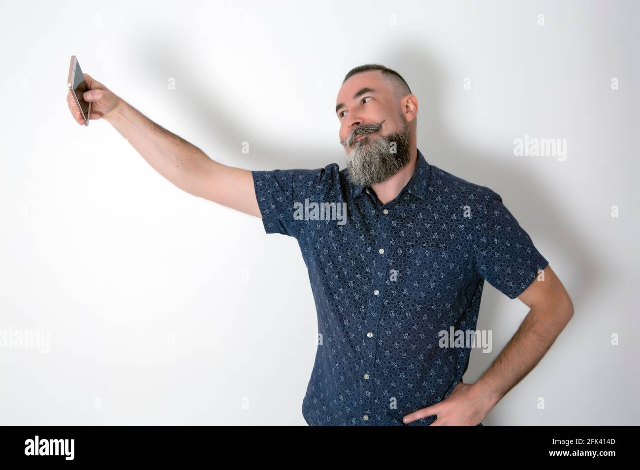 Kaukasische schwule Hipster mit großem Bart 40-45 Jahre alt, ein Selfie mit dem Smartphone Stockfoto