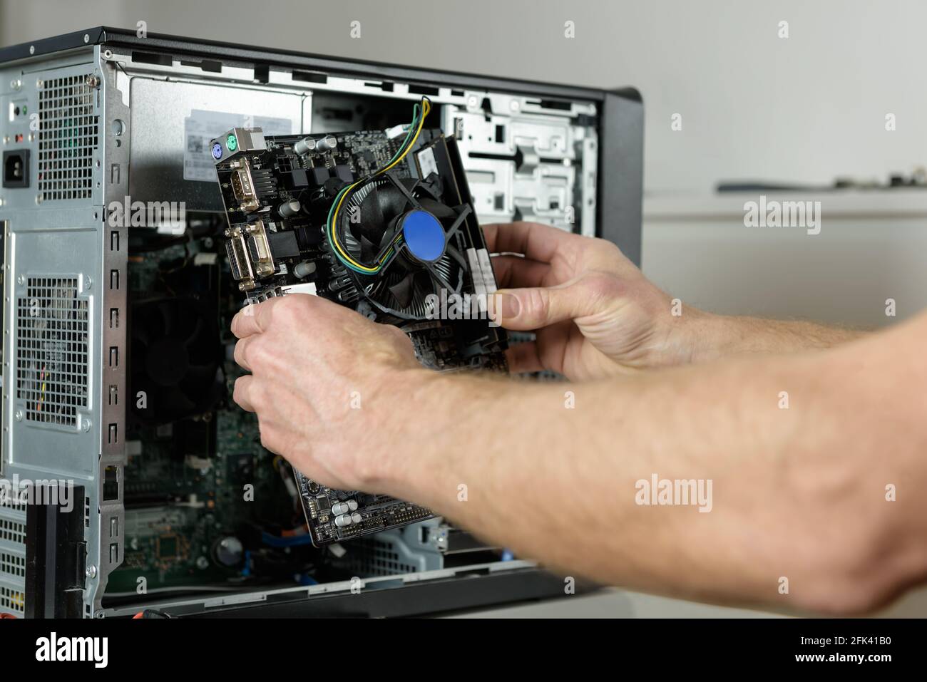 Ein Techniker installiert die Hauptplatine im Desktop-Gehäuse. Stockfoto