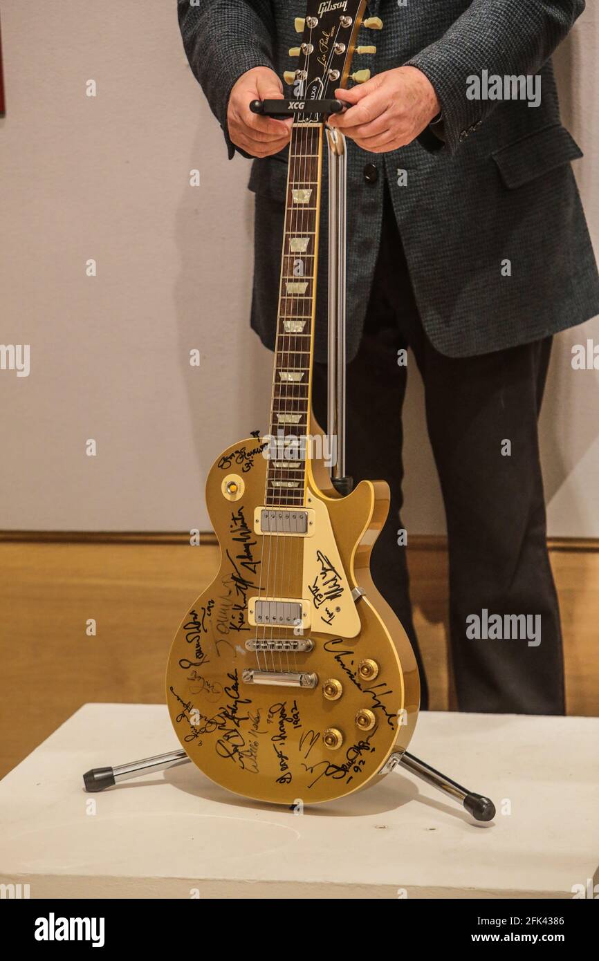 London UK 28 April 2021 Harvey Goldsmith hält die A Les Paul Gold Top Guitar unterzeichnet auf Bob Dylans 30-jähriges Jubiläumskonzert von Stars dort in der Nacht - George Harrison, Eric Clapton, Stevie Wonder und Dylan selbst (Schätzung: £10,000 - 15,000).Paul Quezada-Neiman/Alamy Live News Stockfoto