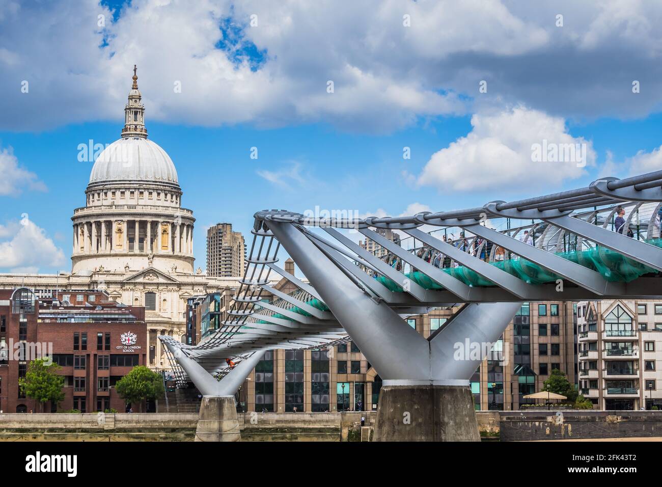 Blick auf die St. Paul's Cathedral und die Millennium Bridge, aufgenommen von der Südseite der Themse an einem sonnigen Tag mit geschwollenen Wolken. Stockfoto