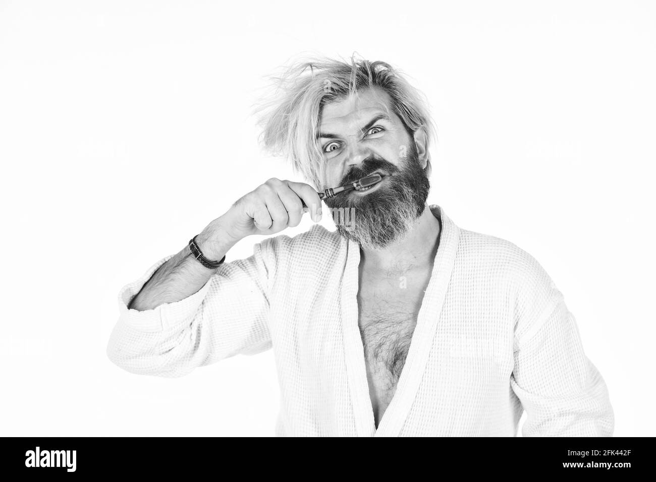Halten Sie die Zähne gesund. Gesunde Gewohnheiten. Zähne putzen. Morgendliche Routine. Mundhygiene. Mann im Bademantel hält die Zahnbürste. Persönliche Hygiene. Bärtiger Hipster Stockfoto