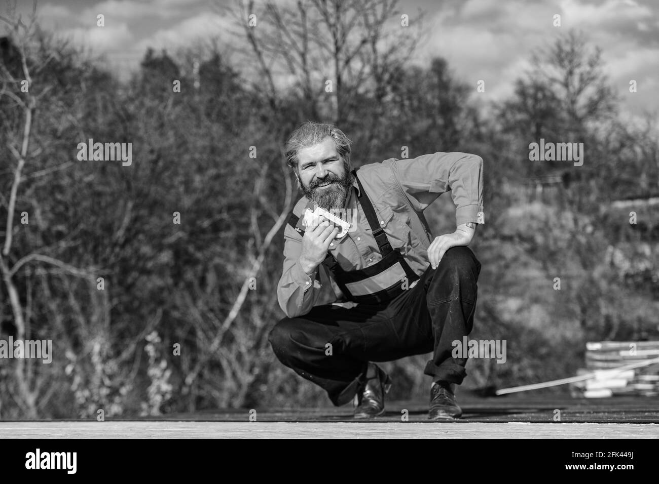 Reparieren oder erstellen. Dachdecker reparieren Dach. Dachmontage. Bärtiger Mann arbeitet im Freien. Dachmechanik-Konzept. Reparatur überprüfen und austauschen. Provisorische Montage Stockfoto