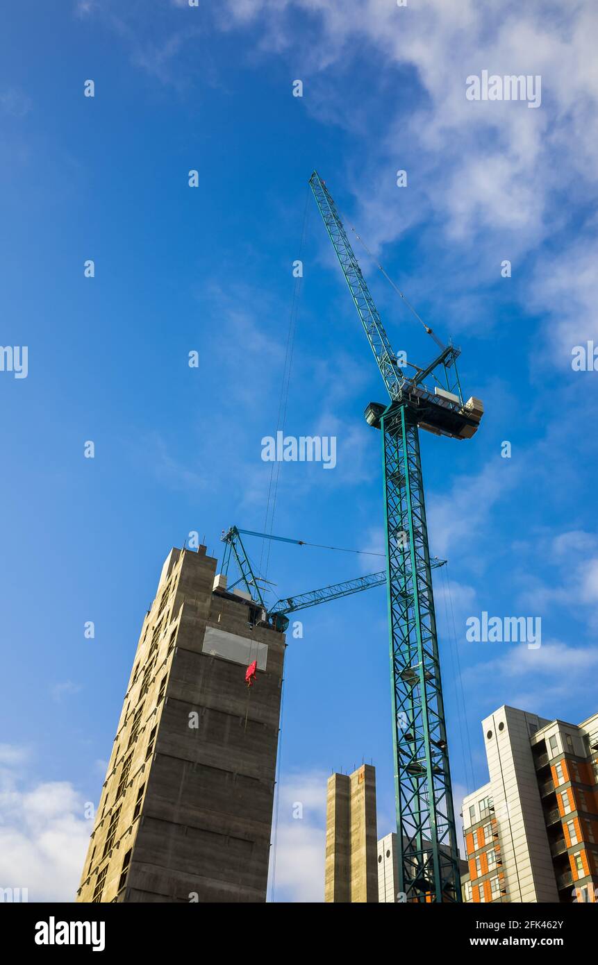 Hochkran, der auf einer Baustelle von Hochhäusern in der Stadt Leeds, England, Großbritannien, betrieben wird. Bau, Entwicklung, Krane und Gebäude Stockfoto