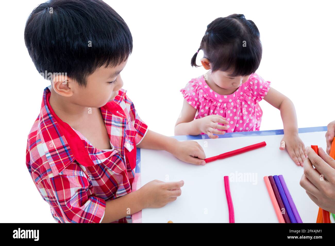 Kleine asiatische Kinder spielen und erstellen Spielzeug aus Spielteig auf dem Tisch, auf weißem Hintergrund. Stärken Sie die Phantasie des Kindes Stockfoto